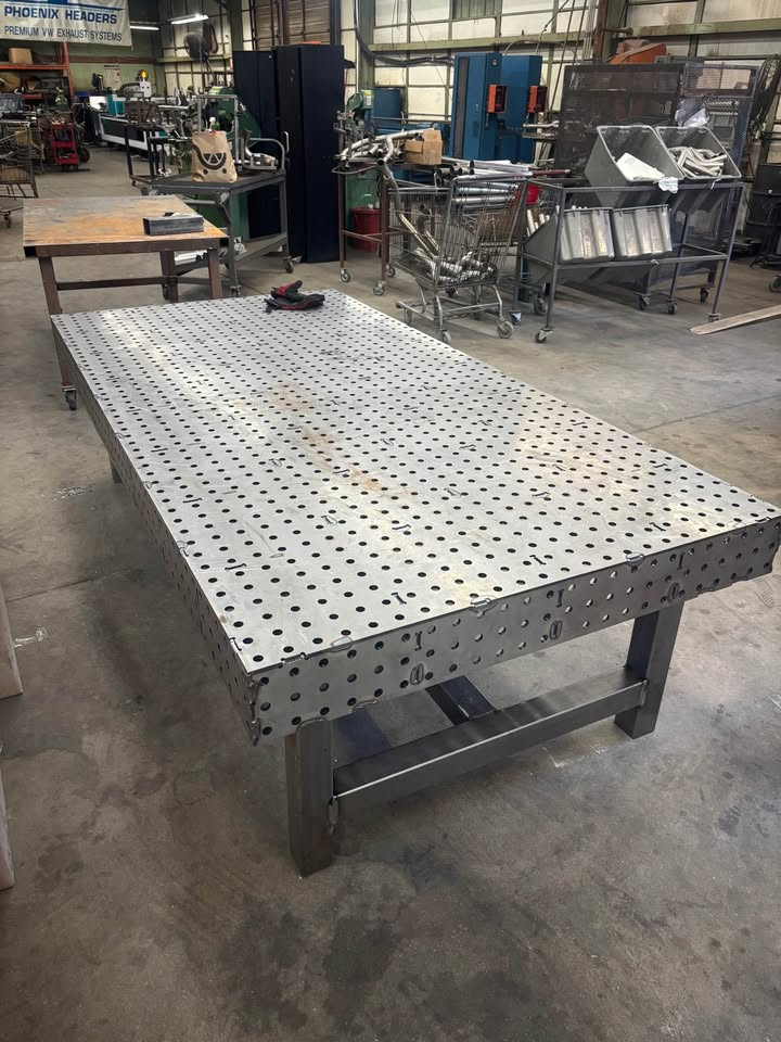 Completed raw-steel Datum welding fixture table shown in an active fabrication shop